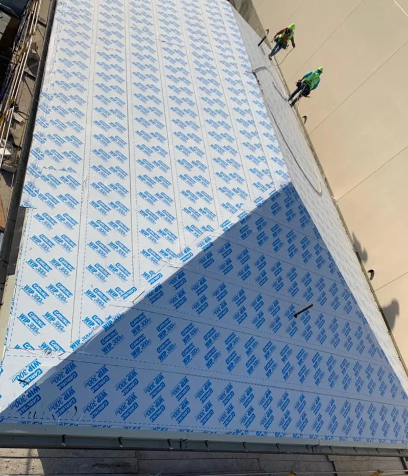 Professional roofers installing underlayment on a metal roof in Canterbury